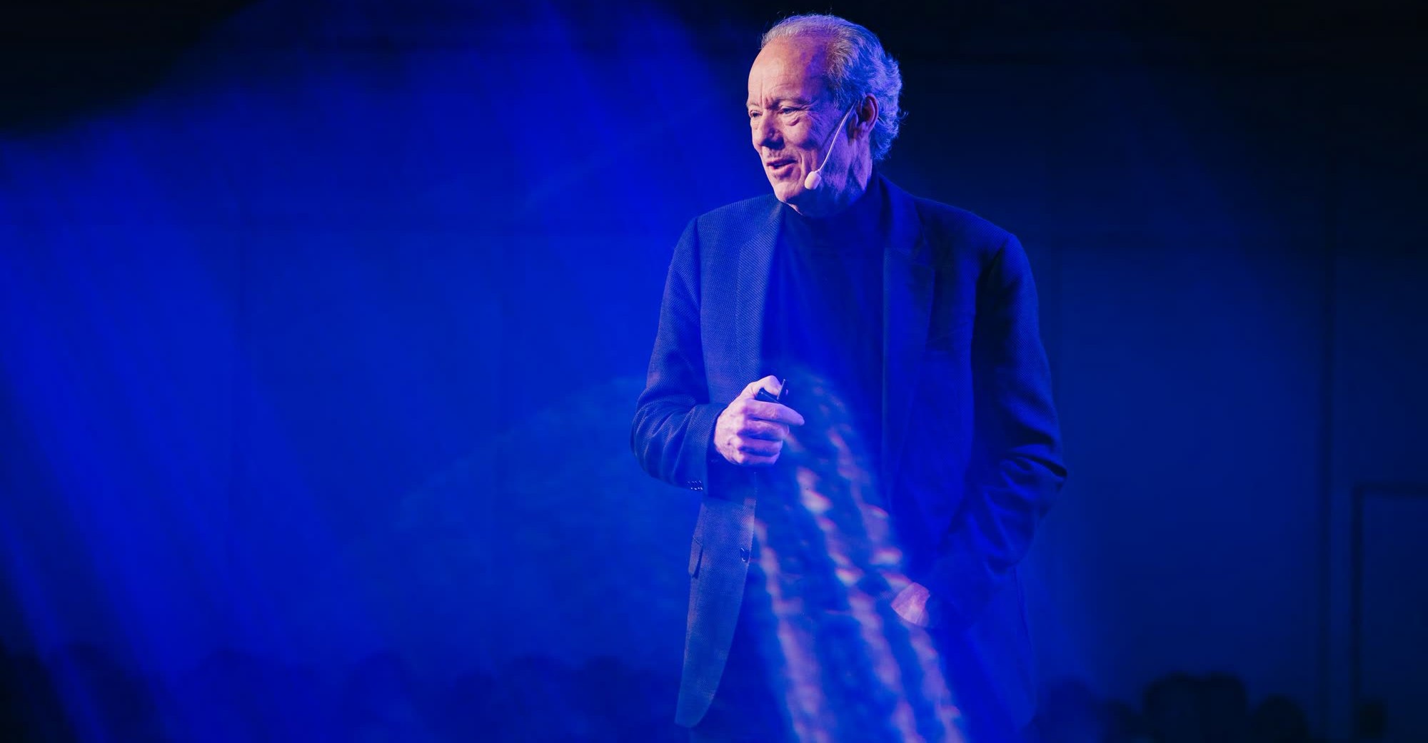 William McDonough speaking on a darkened stage